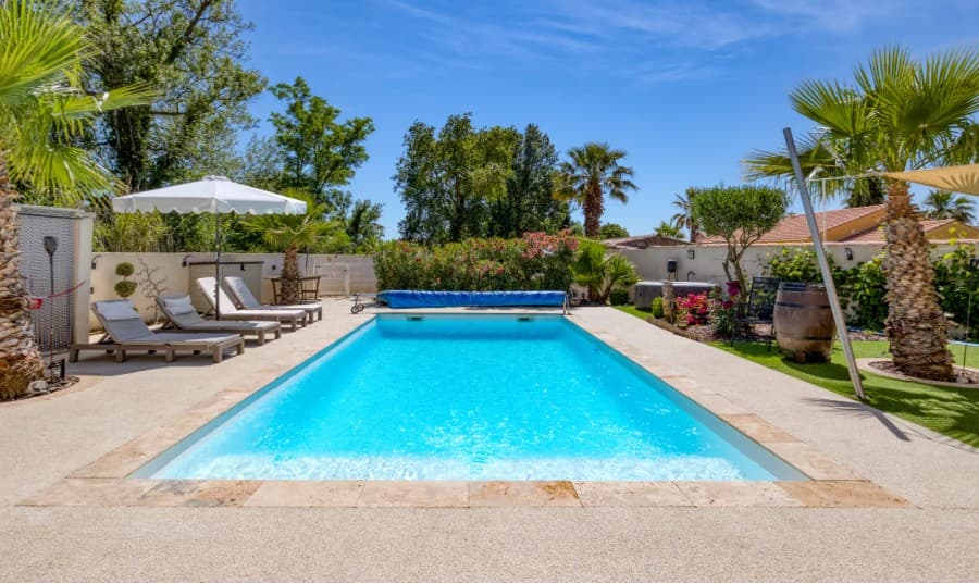 Notre piscine privée avec transats et palmiers